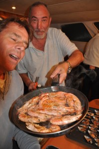 Male chefs cooking gambas for the Catalan fish stew